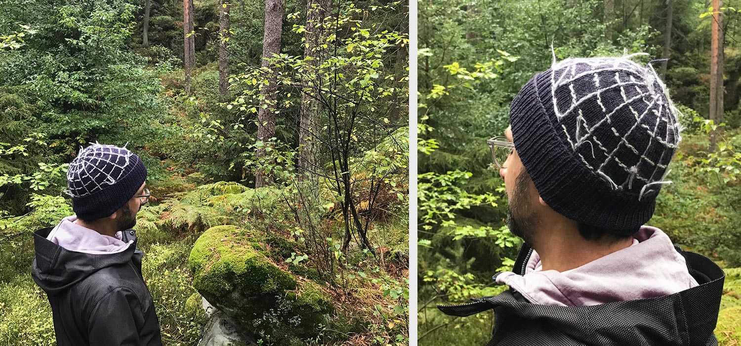 Vincent trägt eine Wollmütze im Wald, die bestickt ist